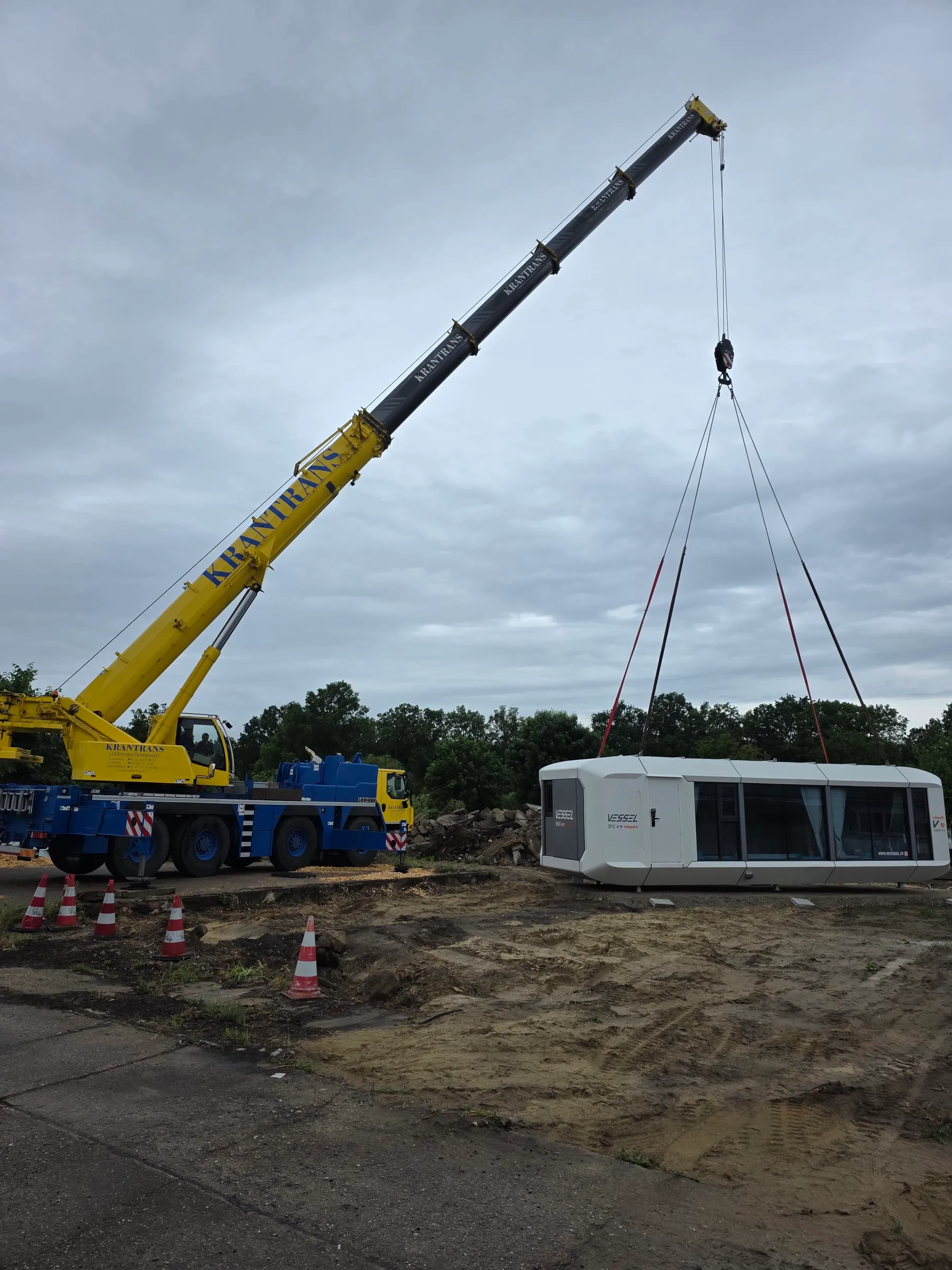 Mobilkran platziert die Wohnzelle MK I auf dem vorbereiteten Standplatz