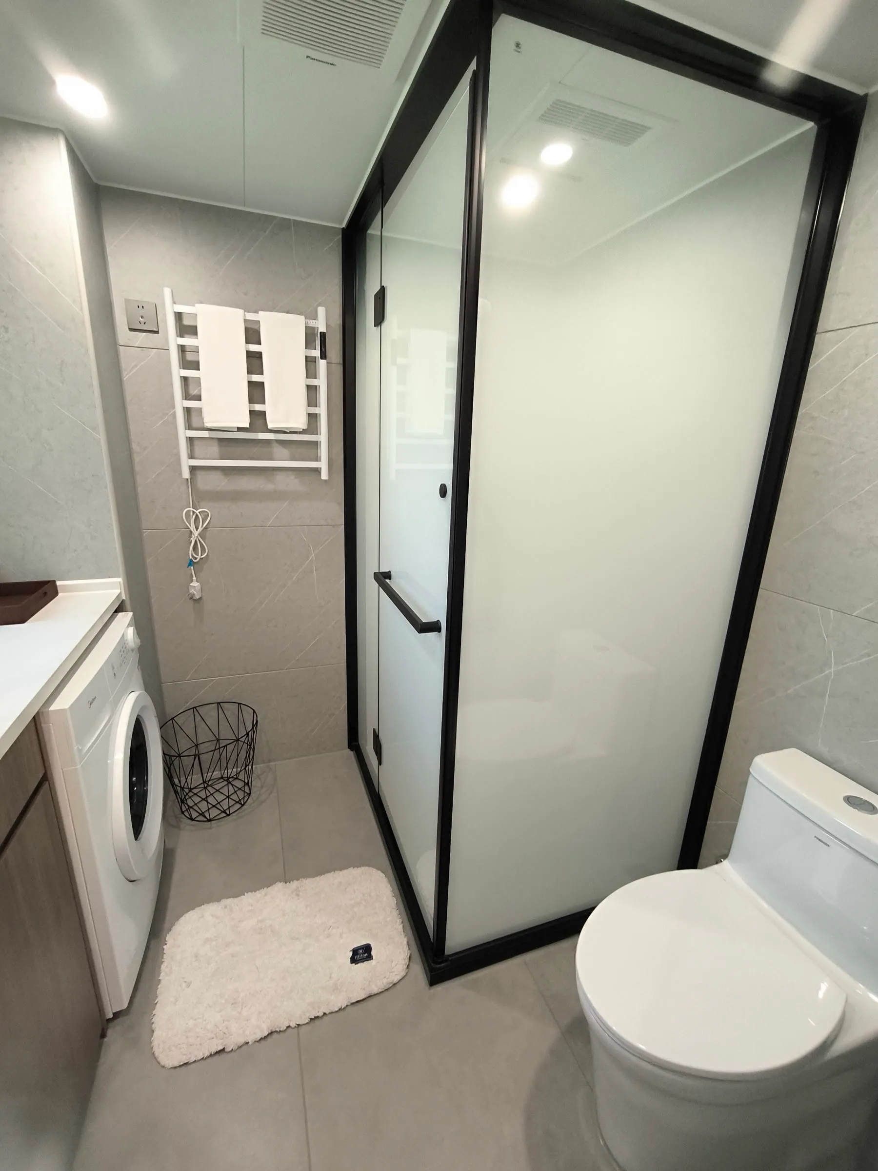 Bad einer Wohnzelle mit Dusche, WC und Waschtrockner
