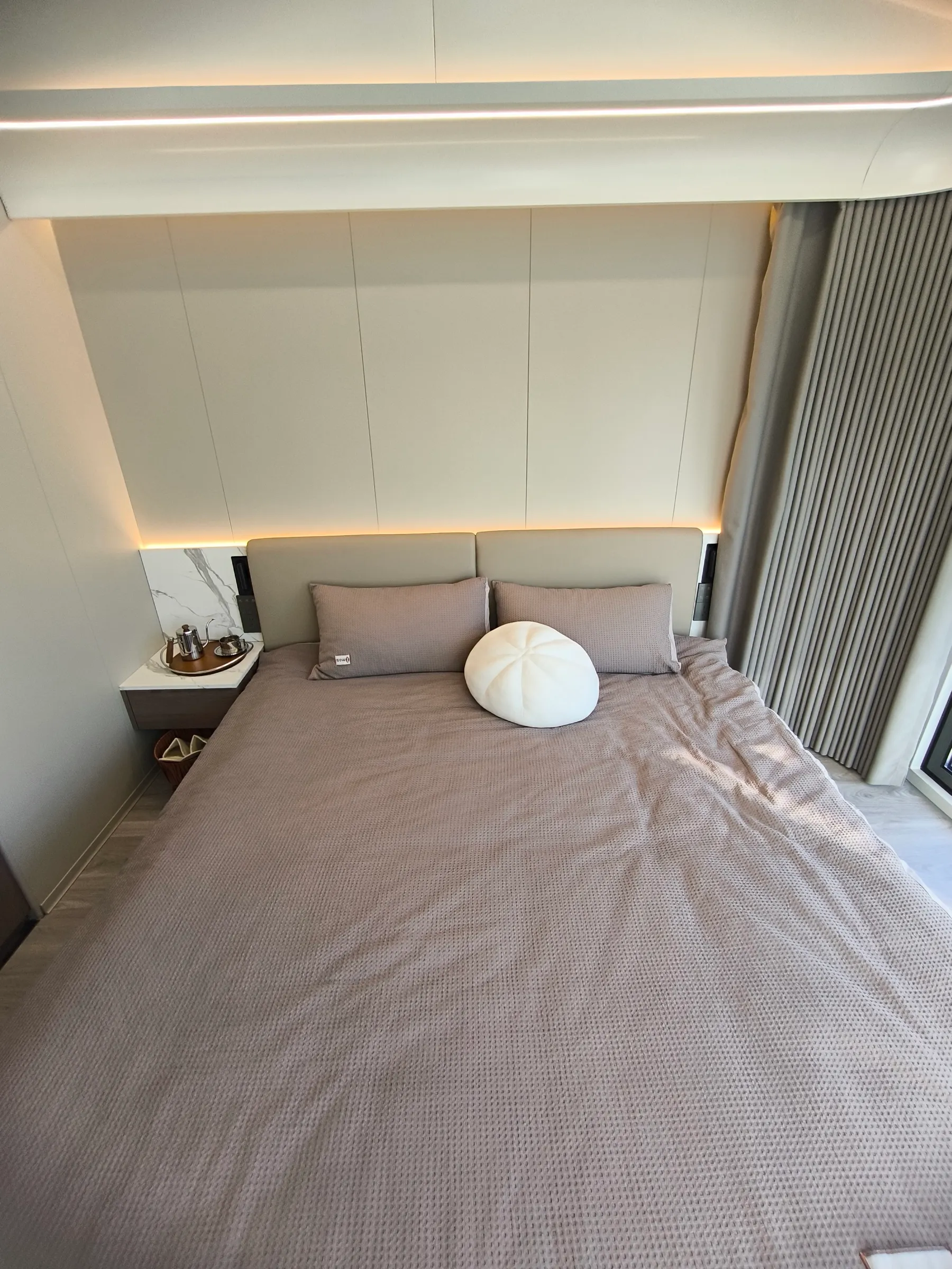 Schlafzimmer der MK II mit Doppelbett, Polsterkopfteil und indirekter Beleuchtung